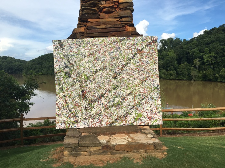 Drip painting in front of chimney with river background.