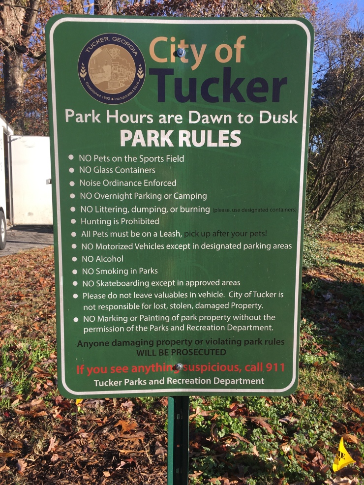 Sign with park hours and rules.